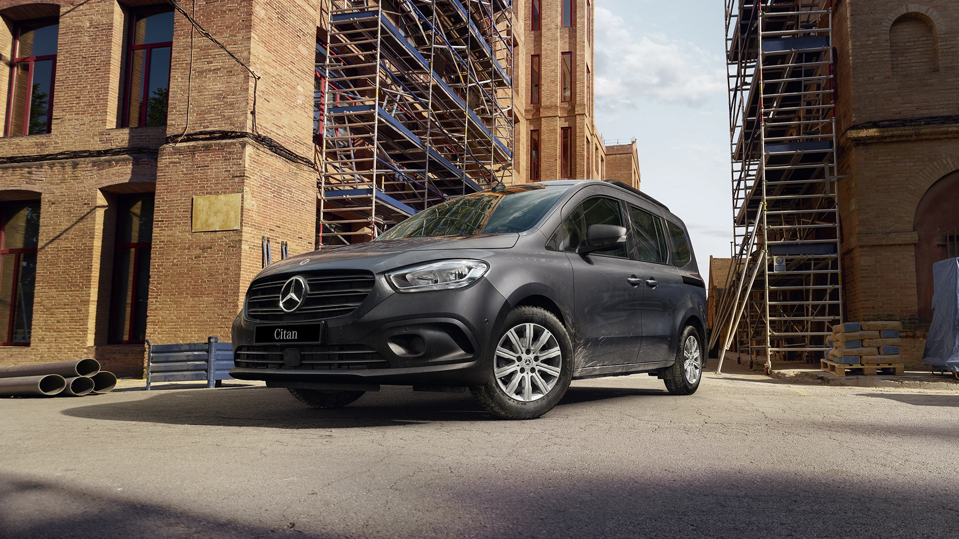 Harmaa Mercedes-Benz Citan pakettiauto rakennuksen edessä