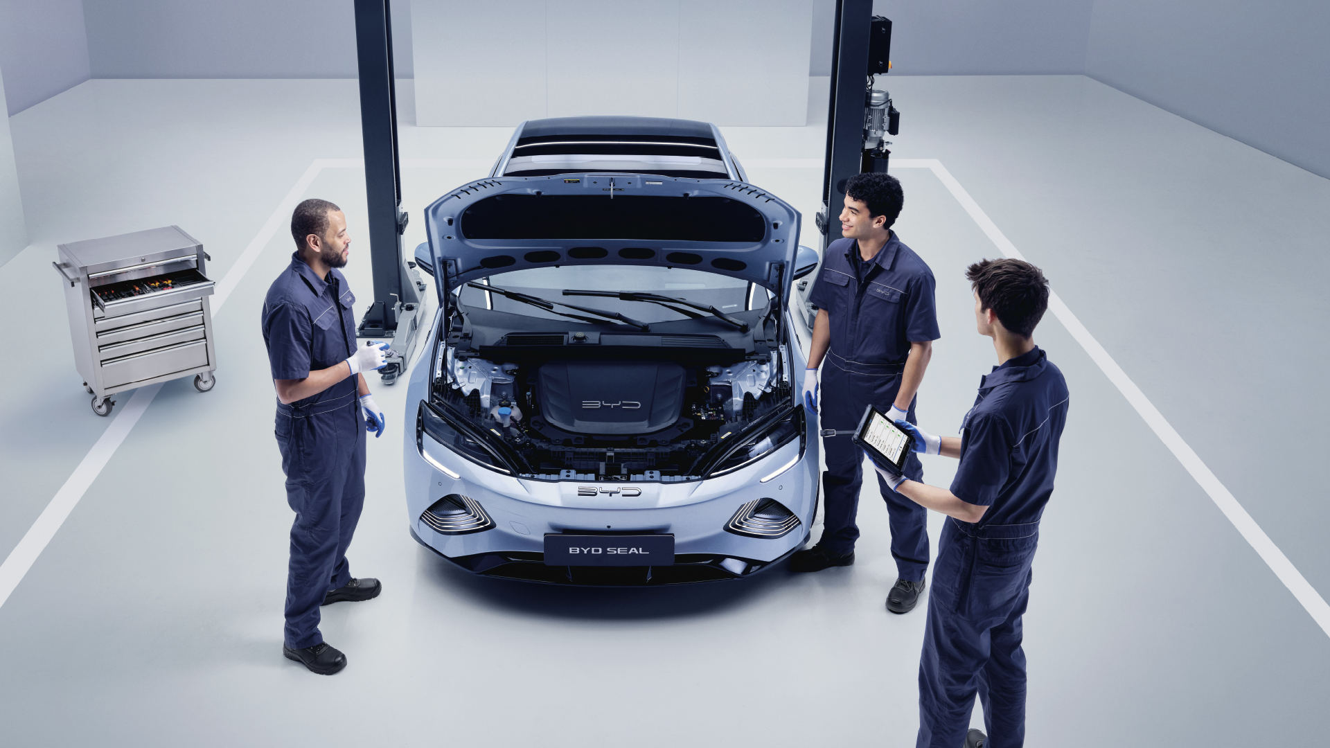 Kolme BYD-mekaanikkoa BYD Seal -auton ympärillä.