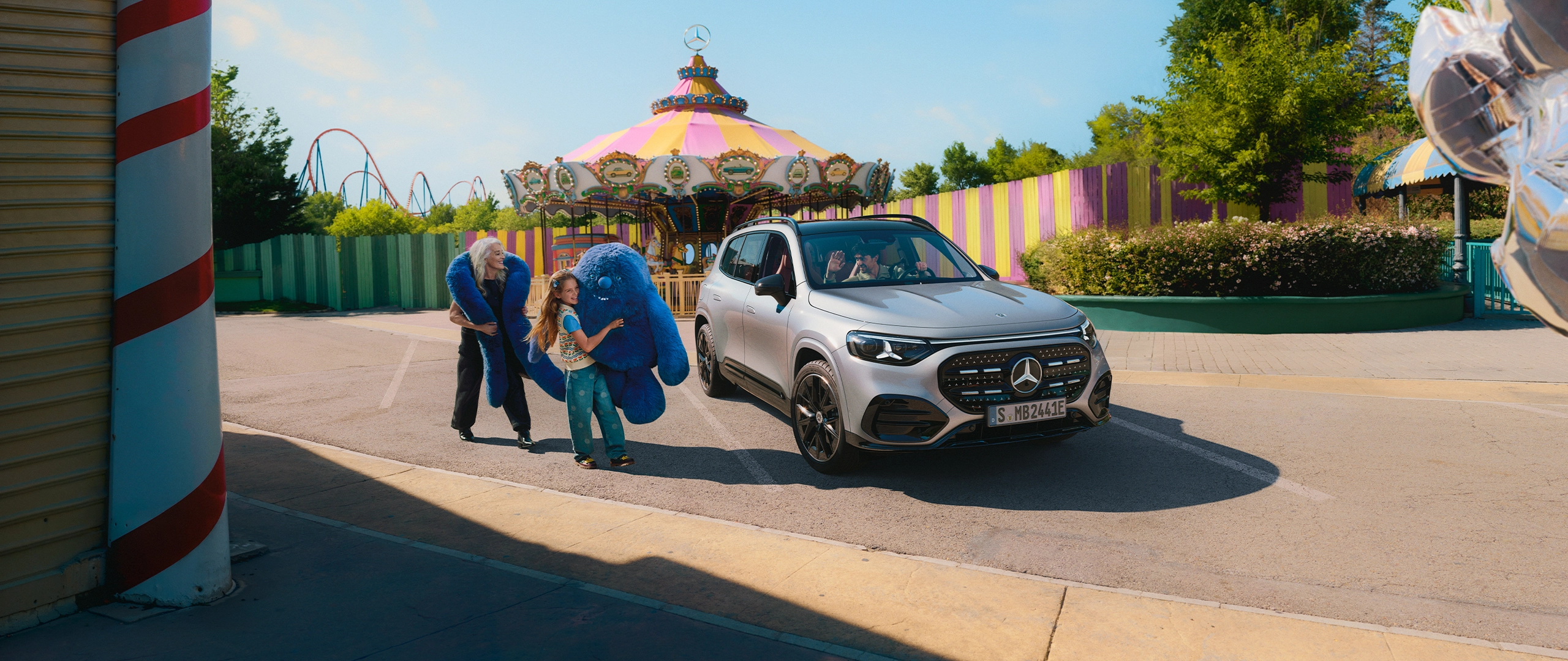 Uusi Mercedes-Benz GLB sähköauto huvipuiston edessä